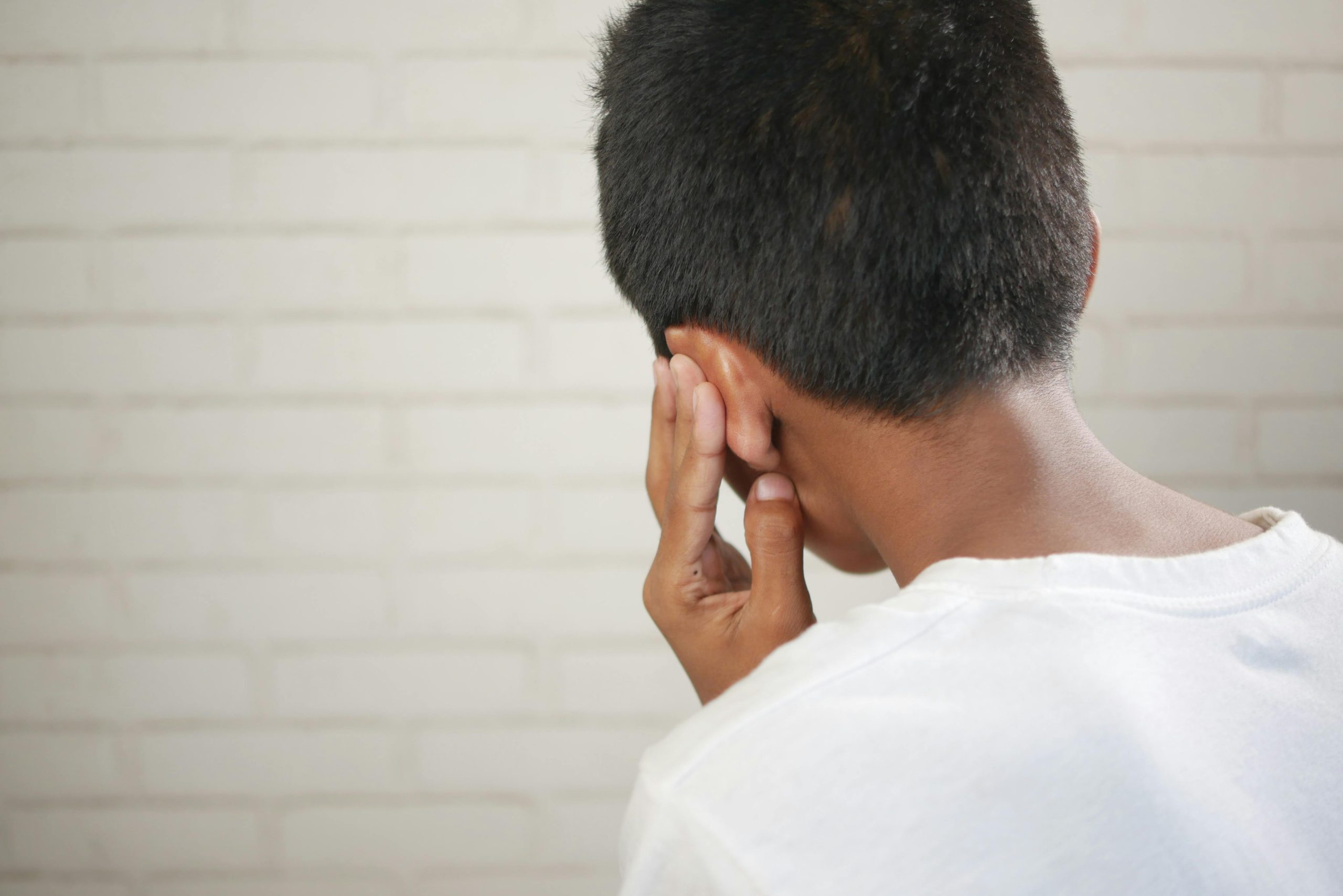 Person holding their ear in pain